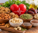 A variety of heart-healthy nuts, dry fruits, and seeds including almonds, walnuts, pistachios, cashews, pumpkin seeds, chia seeds, flaxseeds, and dates arranged around a red heart symbol, representing foods that support healthy cholesterol levels and cardiovascular health.
